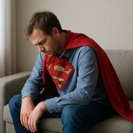 Супермэн спасатель сидит изнеможденный на диване